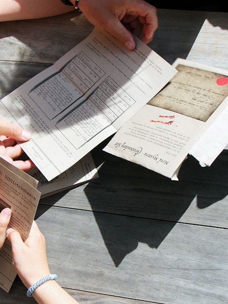 Participants examining mystery hunt clues at Amalienborg Palace.