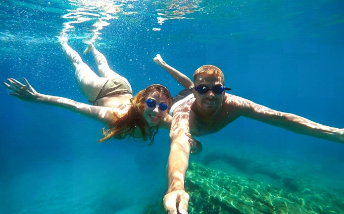 Guests snorkeling in the clear waters of blue caves.