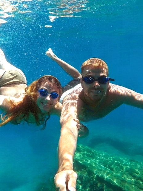 Guests snorkeling in the clear waters of blue caves.