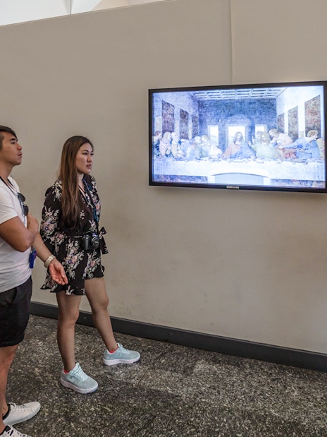 Tour group viewing The Last Supper painting by Leonardo da Vinci in Milan, Italy.