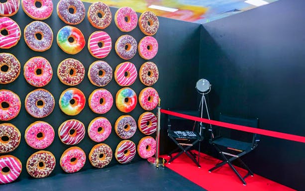 Colorful donut wall at The Selfie Experience Phuket with director's chair and spotlight.