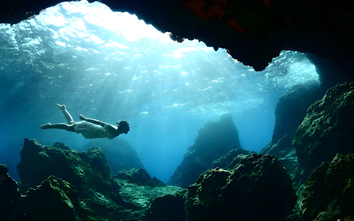 Swimming in the blue caves with sunlight filtering through water.