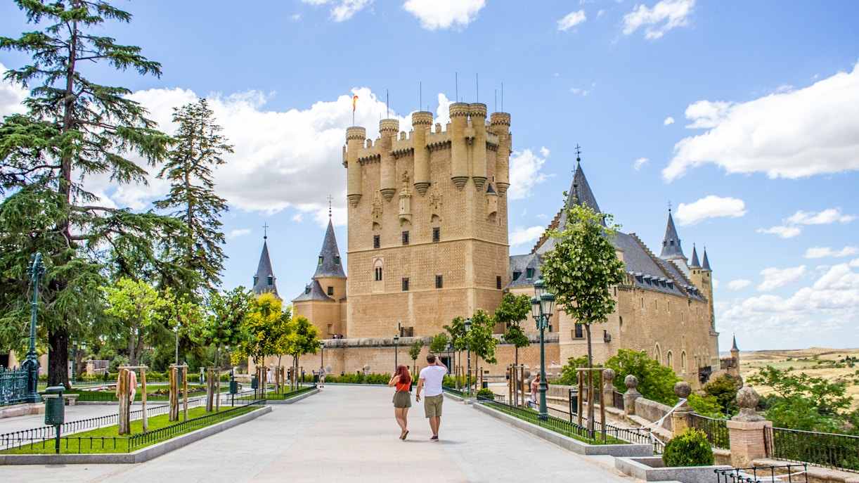 Tourists walking towards the Alcazar of Segovia, Spain.