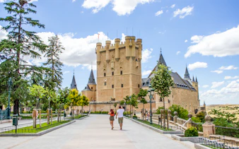 Tourists walking towards the Alcazar of Segovia, Spain.
