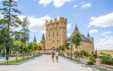 Tourists walking towards the Alcazar of Segovia, Spain.