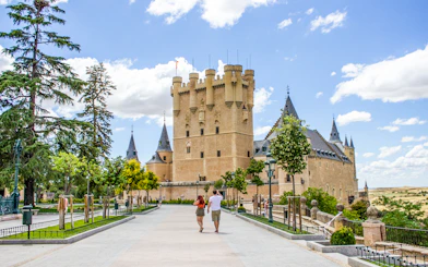 Tourists walking towards the Alcazar of Segovia, Spain.