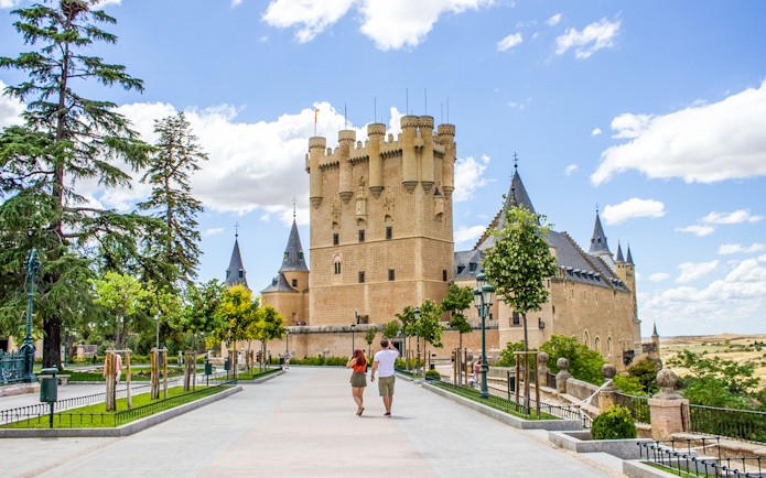 Tourists walking towards the Alcazar of Segovia, Spain.