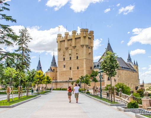 Tourists walking towards the Alcazar of Segovia, Spain.