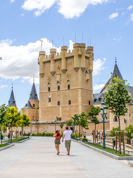 Tourists walking towards the Alcazar of Segovia, Spain.