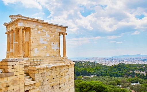 Temple of Athena Nike on the Acropolis with Athens cityscape in the background.
