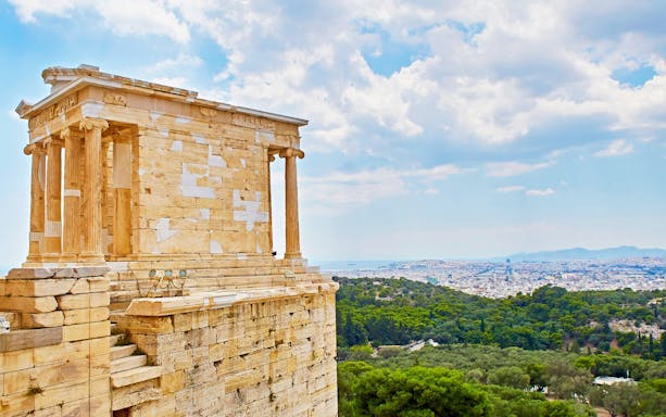 Temple of Athena Nike on the Acropolis with Athens cityscape in the background.