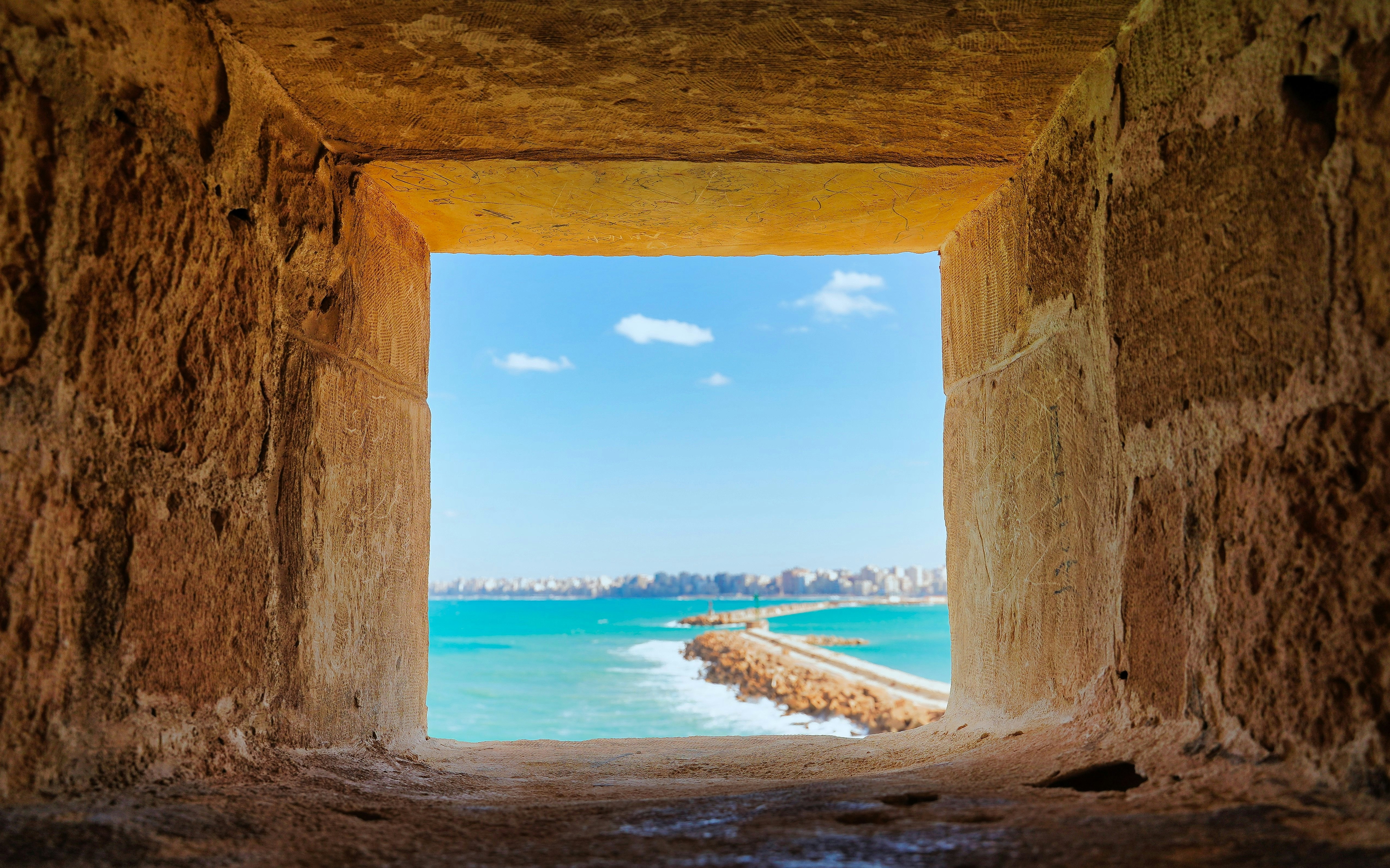 View through a stone window at Citadel of Qaitbay overlooking the Mediterranean Sea.