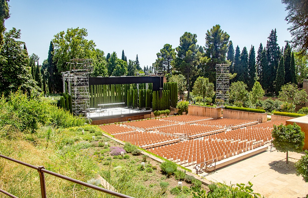 Generalife Theatre stage with lush greenery in Alhambra's Generalife Gardens, Spain.