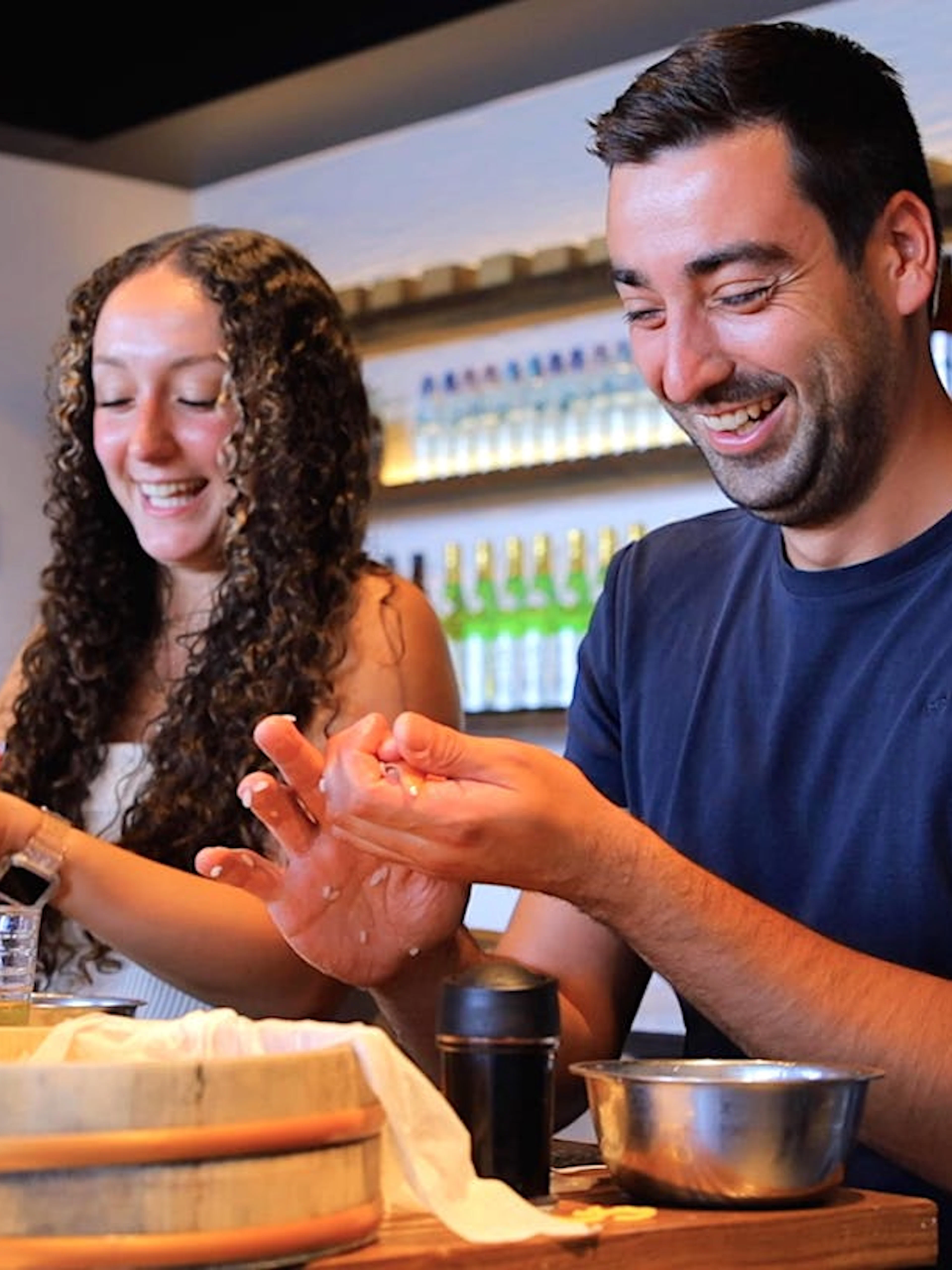 Participants enjoying sushi-making class in Osaka with English-speaking instructor.