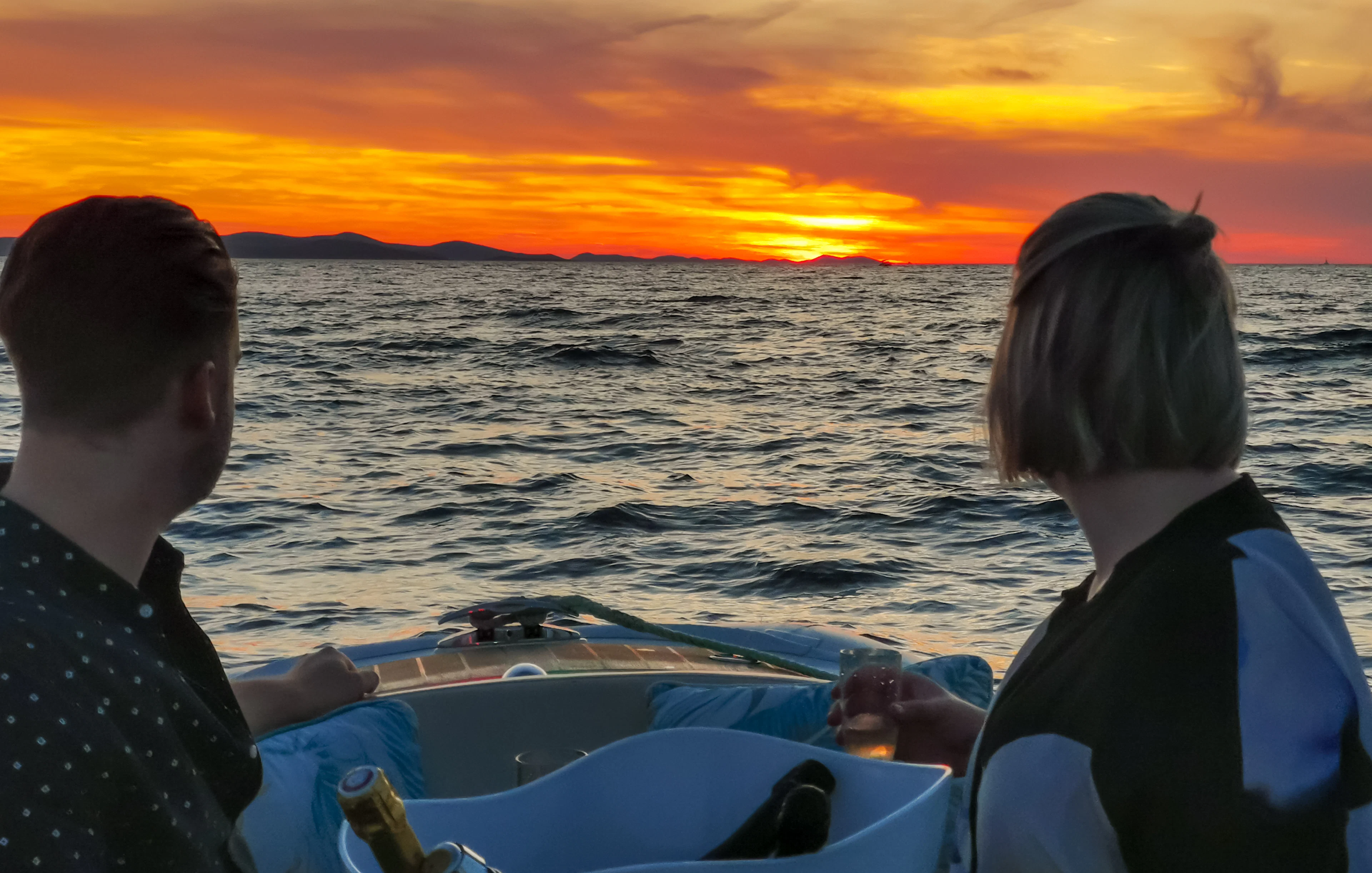 Couple enjoying sunset cruise with sparkling wine near Zadar.