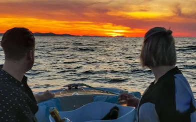 Couple enjoying sunset cruise with sparkling wine near Zadar.