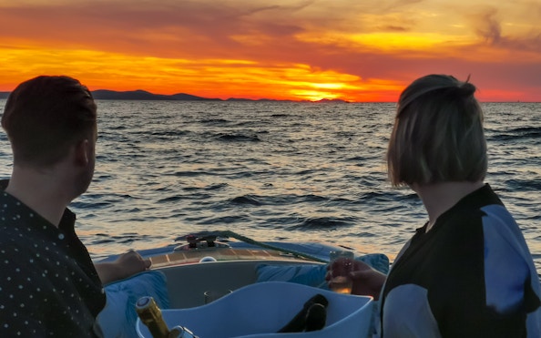 Couple enjoying sunset cruise with sparkling wine near Zadar.