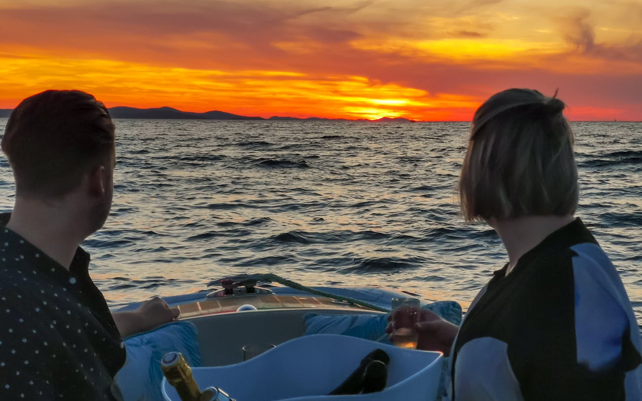 Couple enjoying sunset cruise with sparkling wine near Zadar.