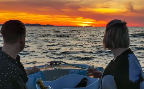 Couple enjoying sunset cruise with sparkling wine near Zadar.