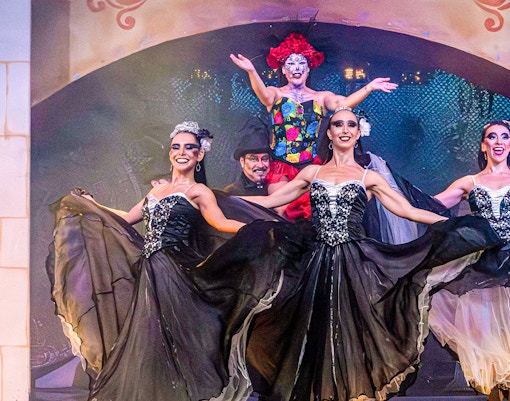 Performers in traditional Mexican attire dancing at Port Aventura's El Día de los Muertos show, Spain.