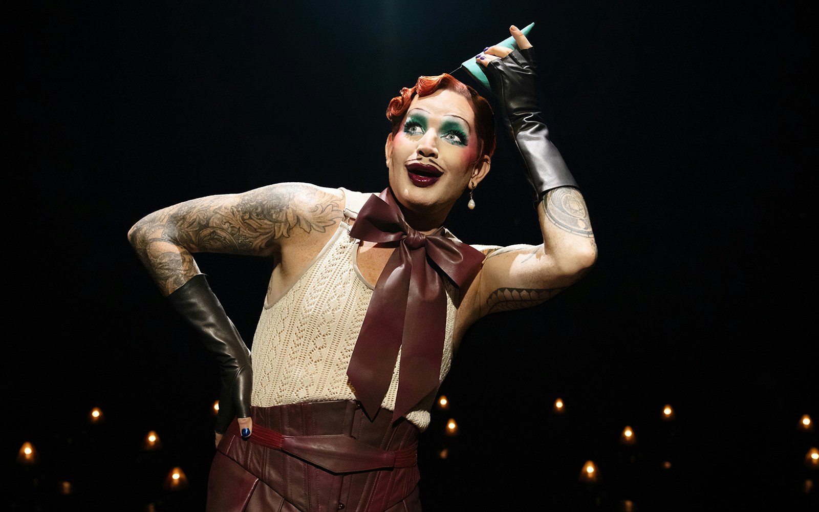 Performer in cabaret show with dramatic makeup and costume.