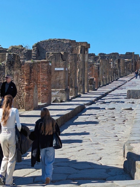 Visitors walking along the ancient cobblestone streets of Pompeii, Italy.