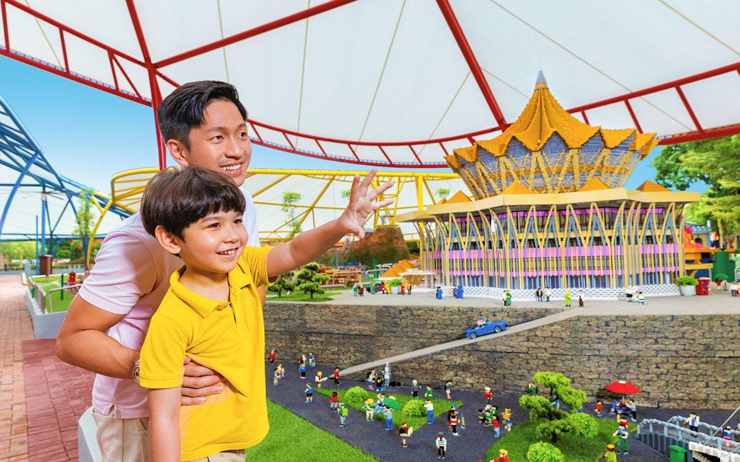 Father and son exploring LEGO Miniland Malaysia at Legoland, featuring iconic landmarks.