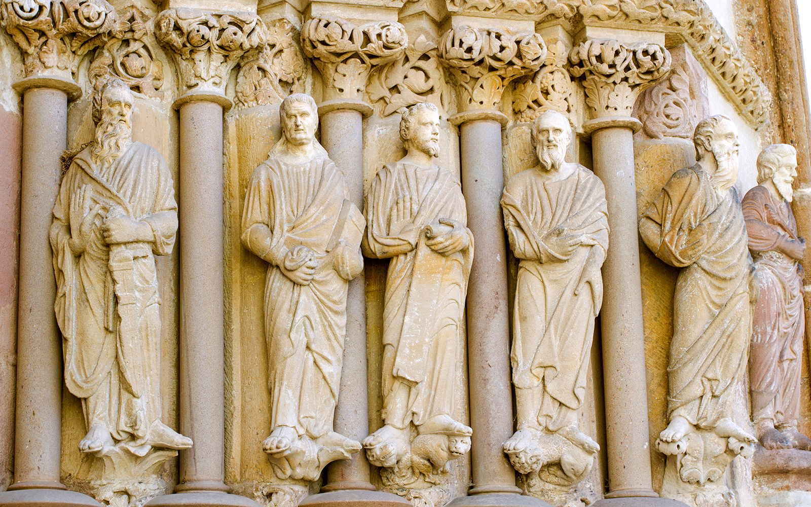 Stone sculptures of apostles on the facade of a Parisian cathedral, Assumption Day tour.