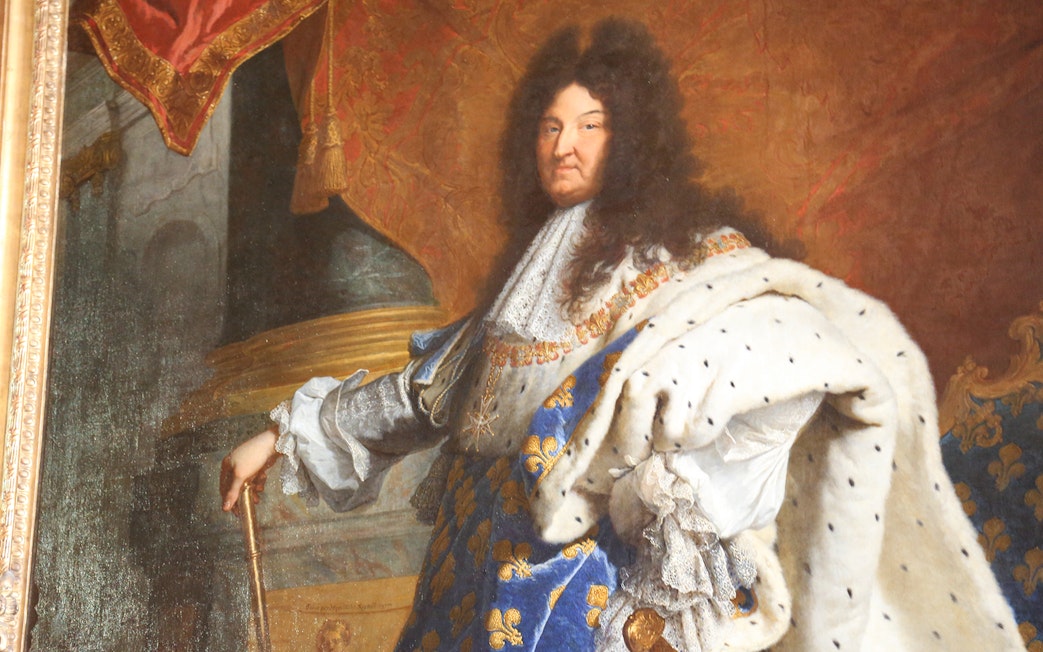 Portrait of a regal figure in ornate attire at the Louvre Museum, Paris.