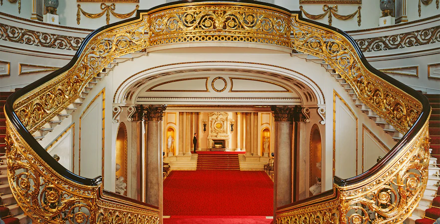 Grand Staircase with ornate gold railings at Buckingham Palace, London.