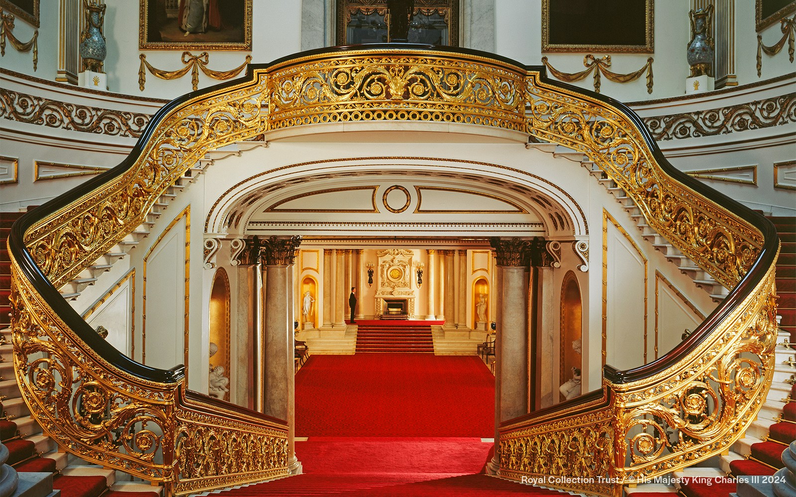 Grand Staircase with ornate gold railings at Buckingham Palace, London.