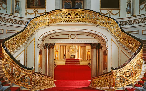 Grand Staircase with ornate gold railings at Buckingham Palace, London.