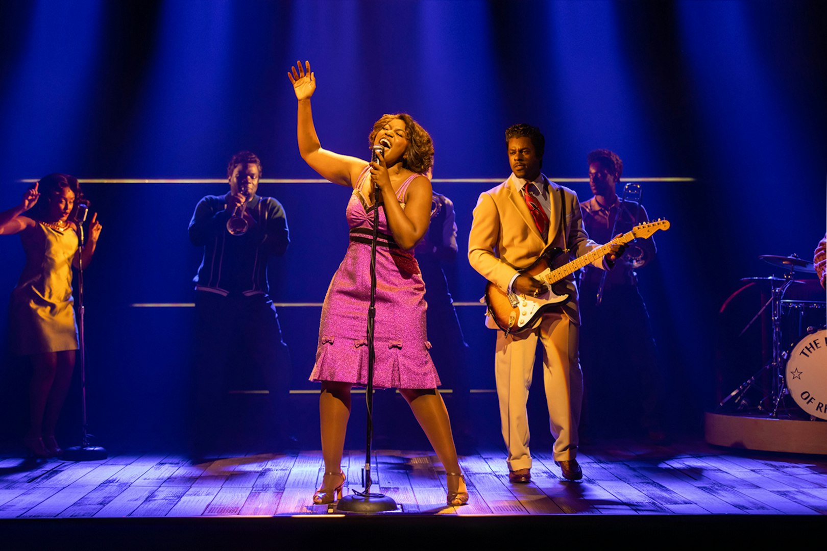 Performer singing on stage with band during TINA – The Tina Turner Musical.