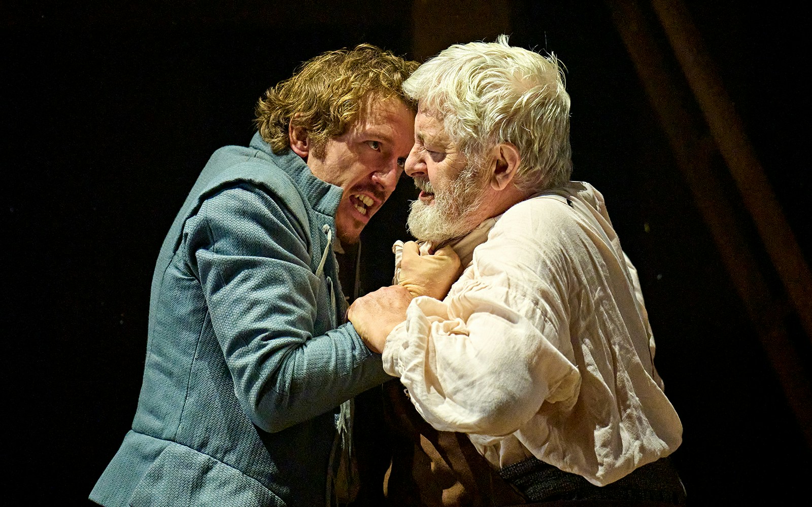 Two actors in a dramatic scene from the play "Hamnet" on stage.