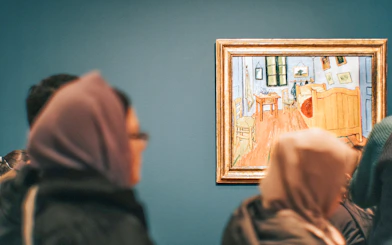 Visitors viewing Van Gogh's "Bedroom in Arles" painting on the Footsteps Van Gogh Tour.