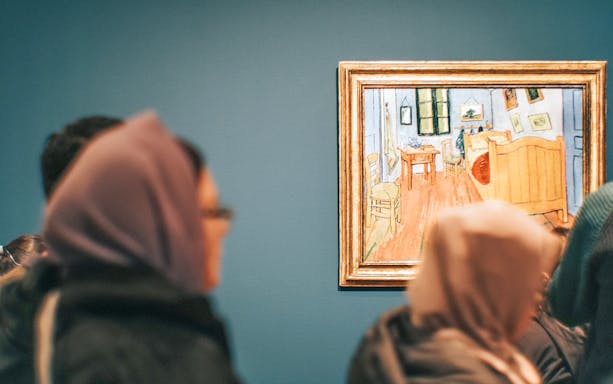 Visitors viewing Van Gogh's "Bedroom in Arles" painting on the Footsteps Van Gogh Tour.