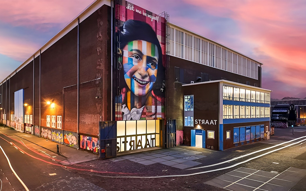 STRAAT Museum exterior with vibrant mural at sunset, Amsterdam.