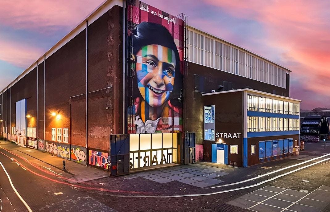 STRAAT Museum exterior with vibrant mural at sunset, Amsterdam.