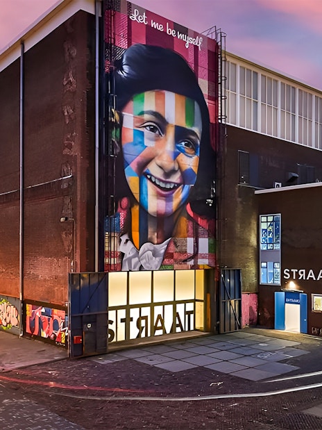 STRAAT Museum exterior with vibrant mural at sunset, Amsterdam.