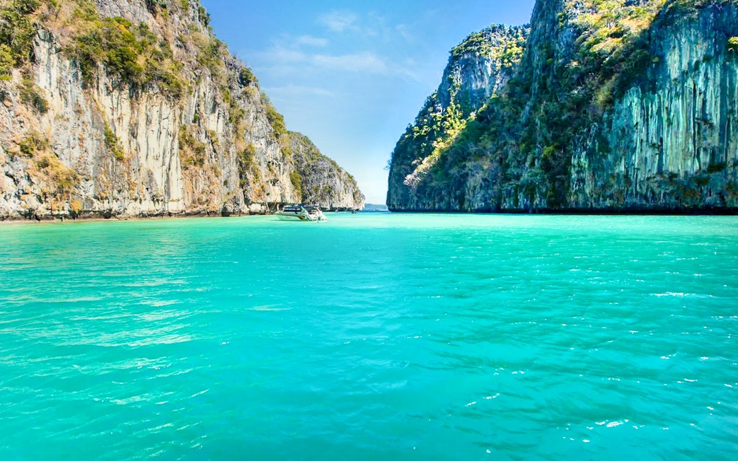 Boat sailing through limestone cliffs towards Maya Bay, Phi Phi Islands.