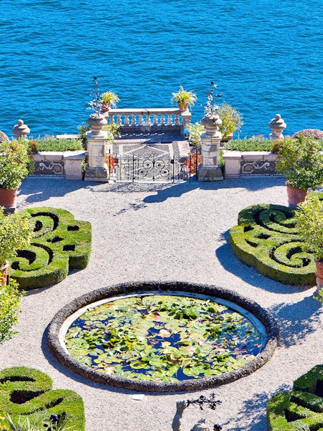 Isola Bella garden with ornate hedges and lily pond overlooking Lake Maggiore.