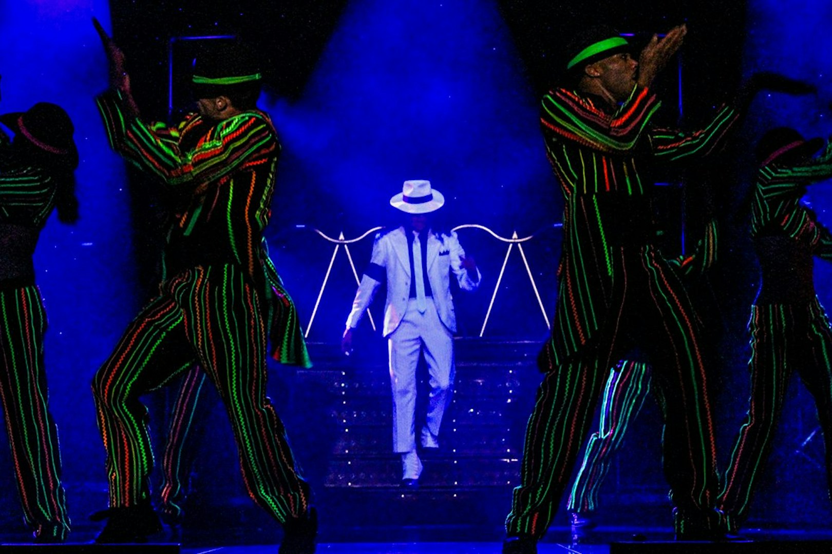Performer in white suit on stage during MJ Live show in Las Vegas.