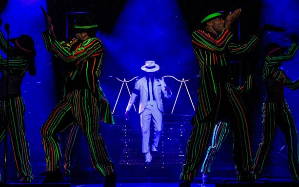 Performer in white suit on stage during MJ Live show in Las Vegas.
