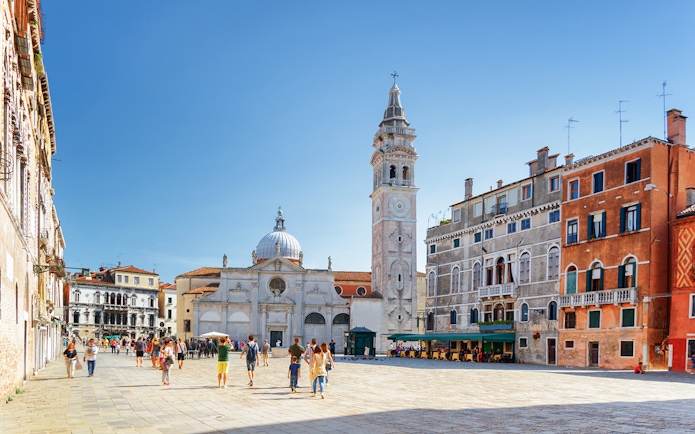 Venice walking tour with people in a piazza near San Giorgio dei Greci church.