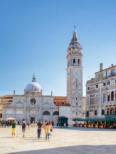 Venice walking tour with people in a piazza near San Giorgio dei Greci church.