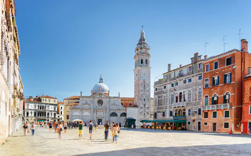 Venice walking tour with people in a piazza near San Giorgio dei Greci church.
