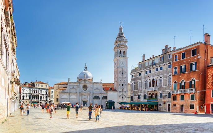 Venice walking tour with people in a piazza near San Giorgio dei Greci church.