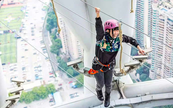 Young kid on a high-altitude rope challenge at Alpha Discovery Park, Canton Tower, Guangzhou, China.