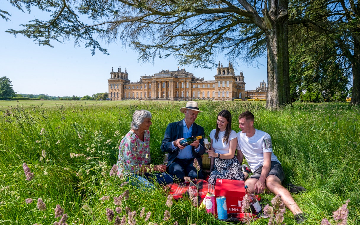Family enjoying a picnic on Blenheim Palace grounds, Oxfordshire.