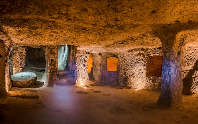 Inside view of Kaymaklı Underground City in Cappadocia, showcasing ancient carved rooms and passageways.